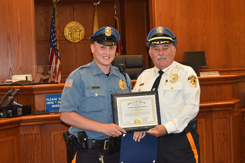 Sheriff’s Officer Andrew Garcia, left a resident of Sea Isle City, receives his award as the highest performing trainee on the academic side of his recent training.