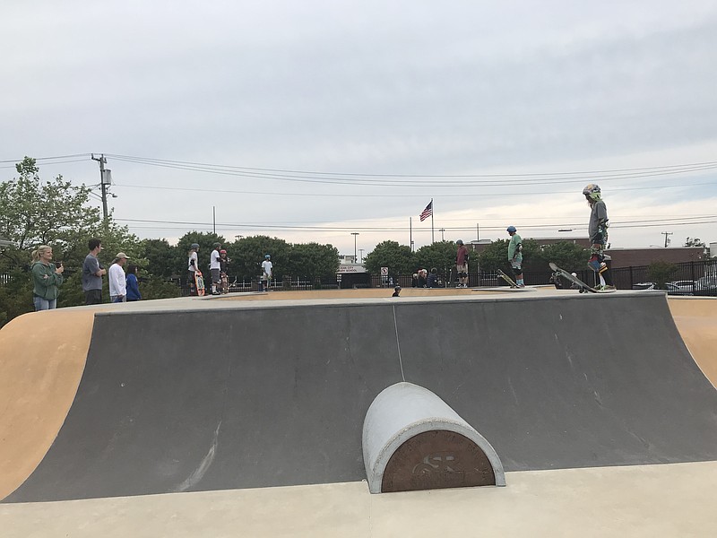 Skaters wait for their turn to take a plunge into the Skatepark's bowl.