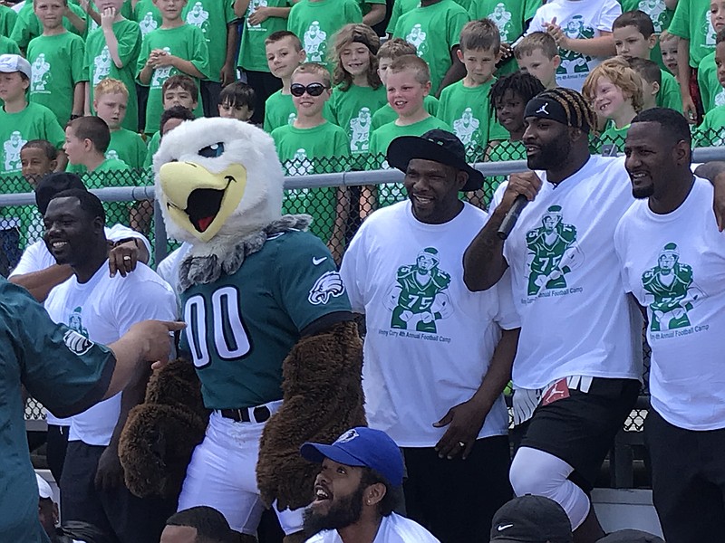 Vinny Curry (second from right), with Eagles’ Alumni member Freddie Mitchell (far right) and some of the 300 attendees at the youth football camp on Saturday at Carey Stadium.