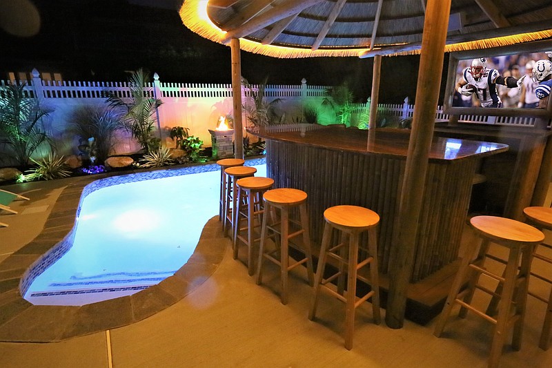 The tiki bar and heated pool give the coastal home a getaway feel.