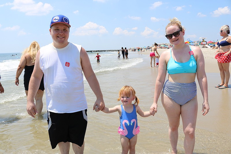 Paul Wermuth, of Folsom, Pa., and his wife, Jill, take their daughter, Elaina, 3, for a stroll at the water's edge. 