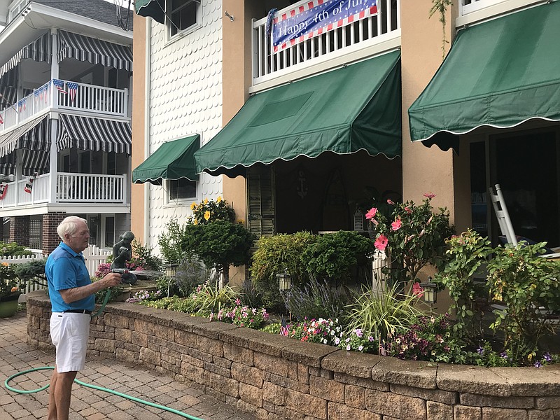 Jim Lavender waters his plants and flowers on Park Place.