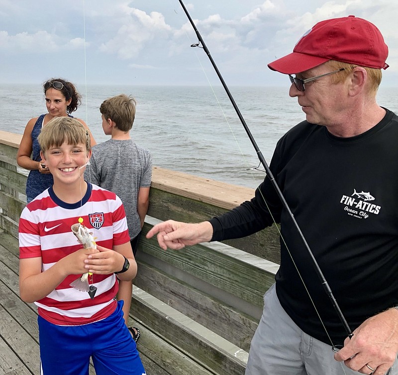 Lukas, 11, of Ocean View, holds a weakfish he reeled in that Ross Seyfert, an Ocean City Fishing Club member, hooked during the club's open house.