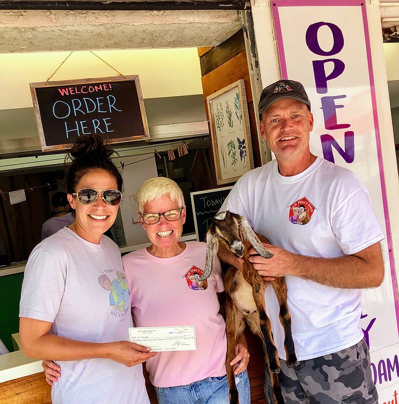 From left, Becky Albertson, owner of The Farm Stand on 14th, presents a check for $1,800 to Christine and Randy Ross, owners and operators of the nonprofit Old Fogey Farm animal sanctuary.