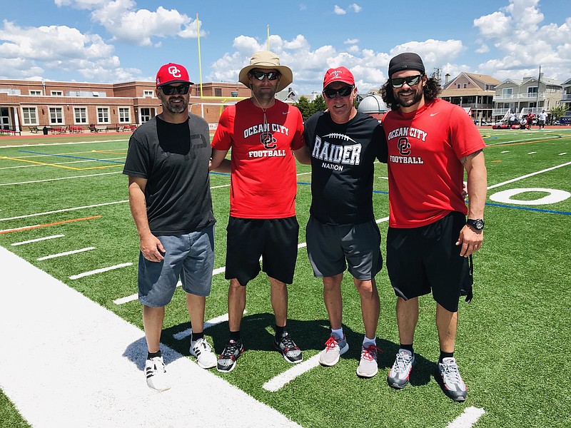 Ocean City Head Coach Kevin Smith (left) with members of his staff at Vinny Curry’s youth football camp.