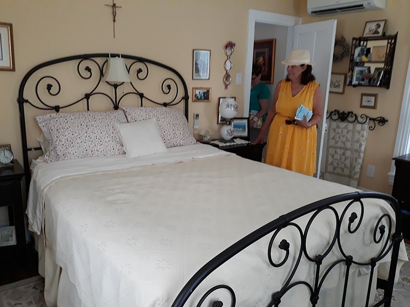 Tour-goer Denise Oponik, a Mullica Hill, N.J., resident who has a vacation home in Ocean City, admires the master bedroom of the Folk Victorian house.