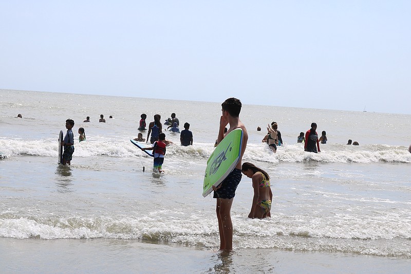 Surfers enjoy 7th Street beach.