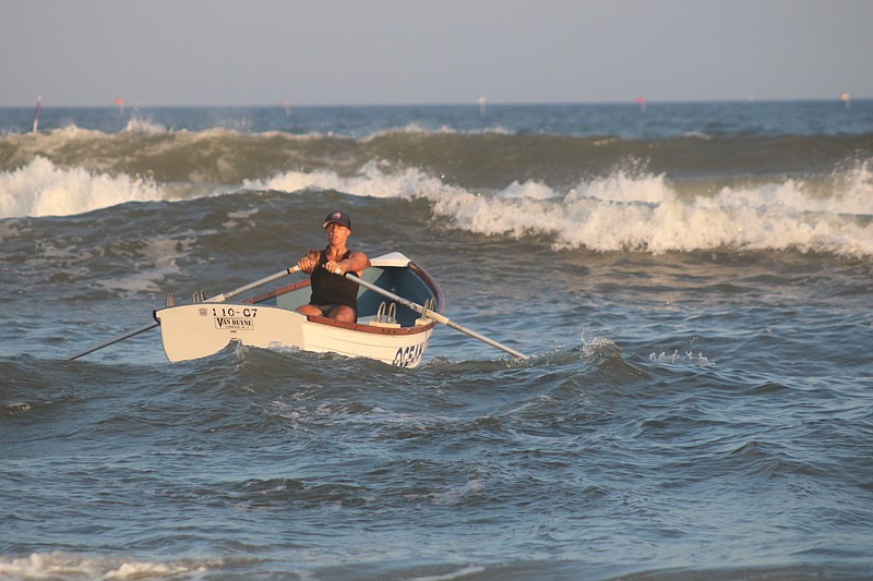 Stephanie Hauck rows out through the surf.