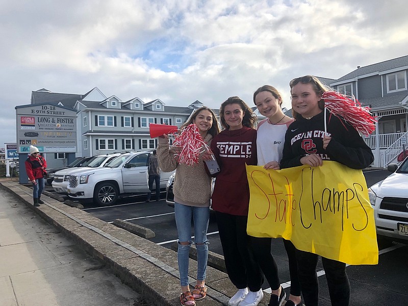 Carrying a "State Champs" banner, Ocean City High School supporters greet the girls soccer team as it arrives back in town.