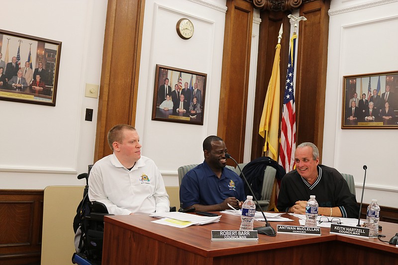 From left, Council members Bob Barr, Antwan McClellan and Keith Hartzell share a light moment at Thursday's meeting.