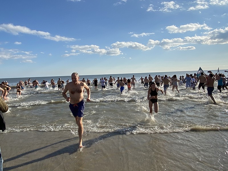 Plungers hurry out of the frosty water after charging into the surf in 2020.