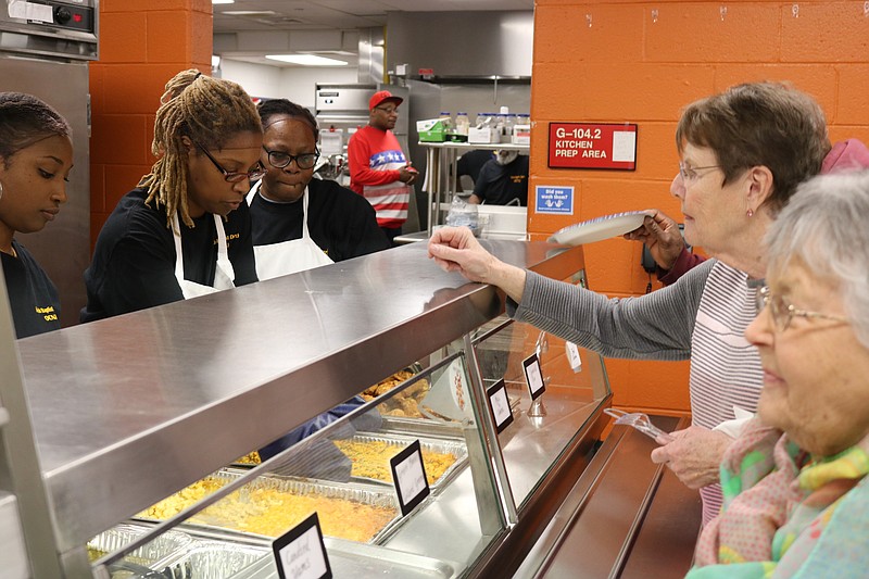 People line up for a soul food luncheon.