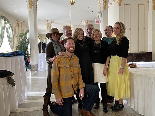 Patrick Burns, kneeling, next to wife, Bri, and surrounded by family and friends at Bri’s baby shower. The couple are expecting twin boys in May.