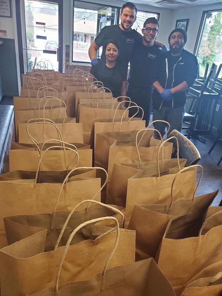 Maria Garcia, Gino Brizzi, Anthony Gerace and Adan Ramiriz of Marsini’s Kitchen with some of the dinners they prepared to be delivered for free to those in need as a result of the coronavirus outbreak. 