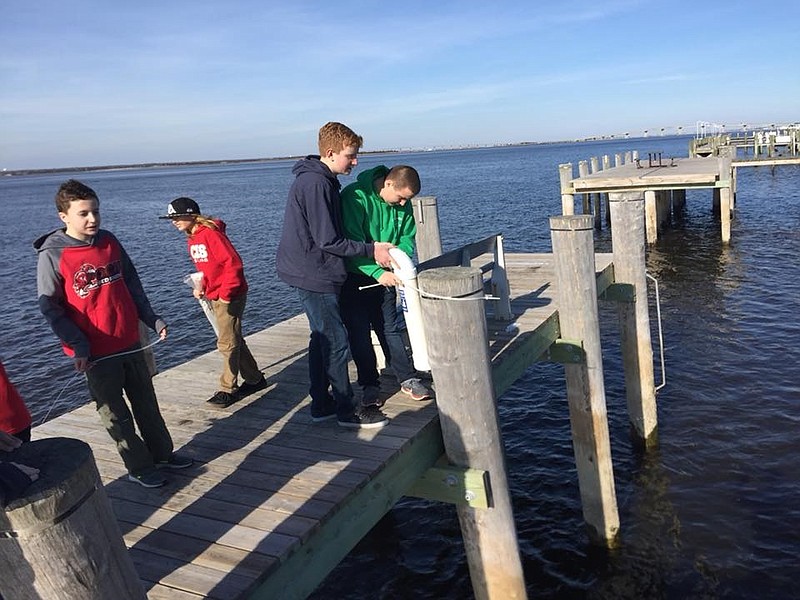 Eagle Scout Dylan Kampf installs a fishing line receptacle on a dock in Ocean City.