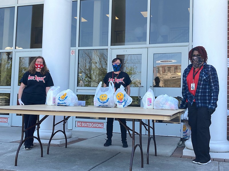 From left: Jen Town Rolls, Tina Mosher (director of food services) and Sheila Jones wait for families of students of the lunch program to pick up bags of food at Ocean City High School.