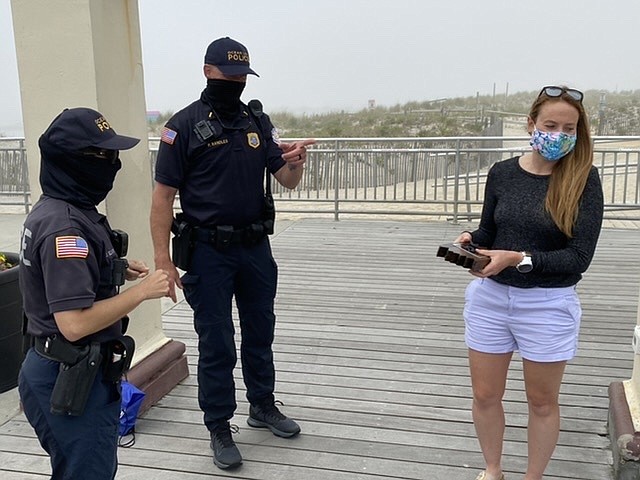 Britt Miller reacts to receiving her “piece of the Boardwalk,” a plaque made from Ocean City’s famous wooden way, from Officer Jen Elias and Lt. Pat Randles of the OCPD.