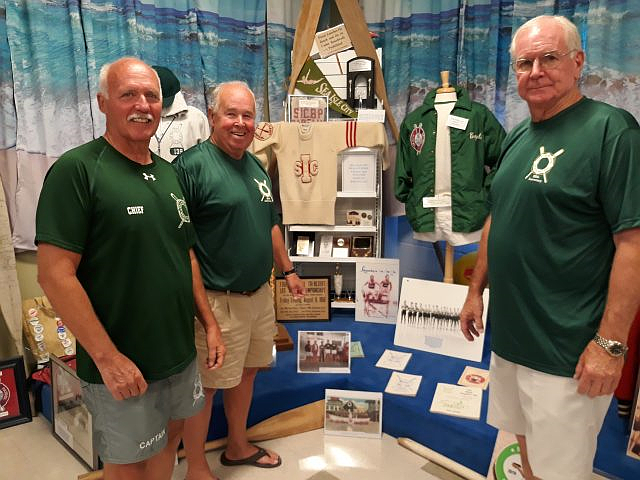 Sea Isle City Beach Patrol Chief Renny Steele (left) is joined by former Captains Bill Gallagher (center) and Mike McHale in front of a Beach Patrol exhibit at the Sea Isle City Historical Museum.