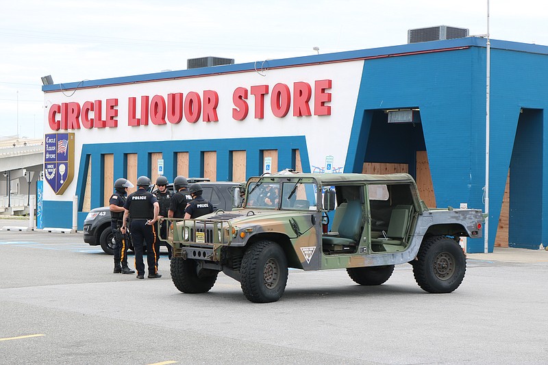 A boarded up Circle Liquors in Somers Point has police presence to watch the protesters on their way across the Route 52 Causeway into Ocean City.