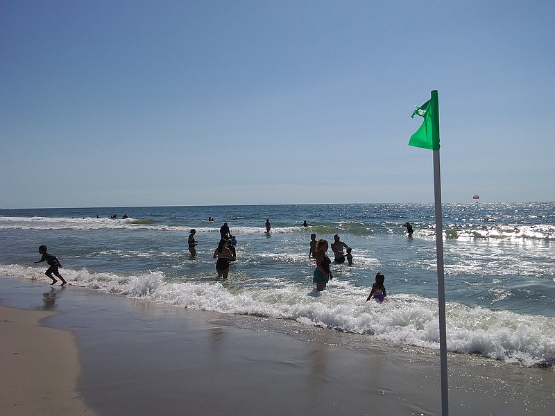 Swimmers enjoy warm waters on a sunny day at Eighth Street Beach.