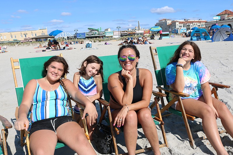 Christina Molina, of Levittown, Pa., glasses, with her daughters, from left, Julianna, Gianna and Alaina, find a perfect place to sit at Ninth Street beach near the water's edge.