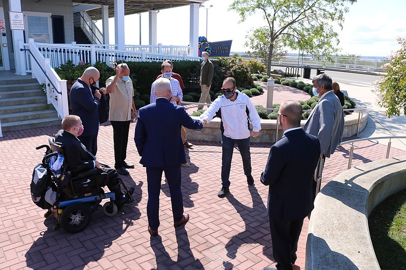 Congressman Jeff Van Drew greets City Councilman Jody Levchuk, in white shirt,  with a fist bump while maintaining social distance.