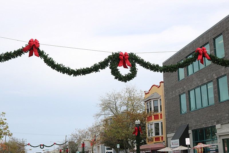 Wreaths are draped with garland across Asbury Avenue on each block.