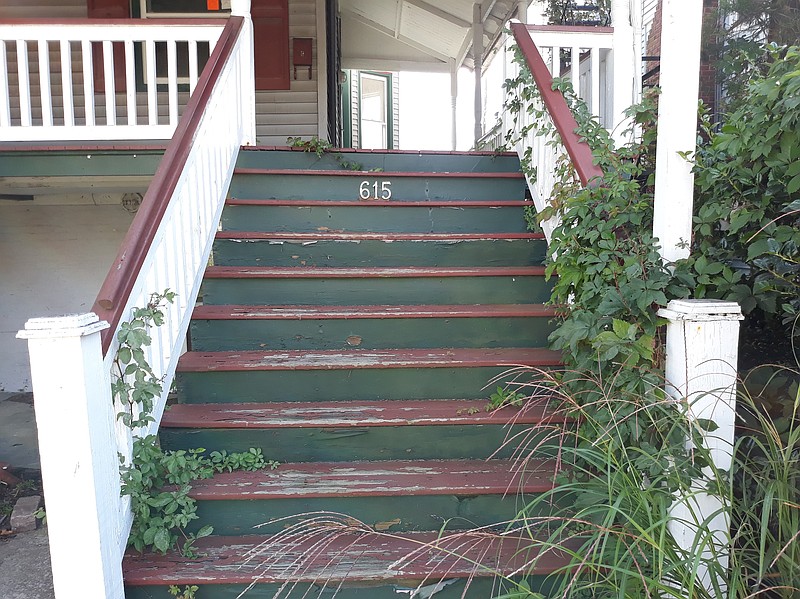 Overgrown vines and weeds are creeping up the front steps at the old home.