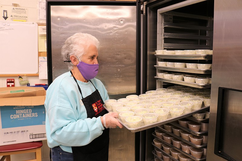 Kathy Thompson, of Ocean City, puts a tray of homemade coleslaw into the freezer at St. Peter's United Methodist Church in preparation for the free Christmas dinner for those in need.