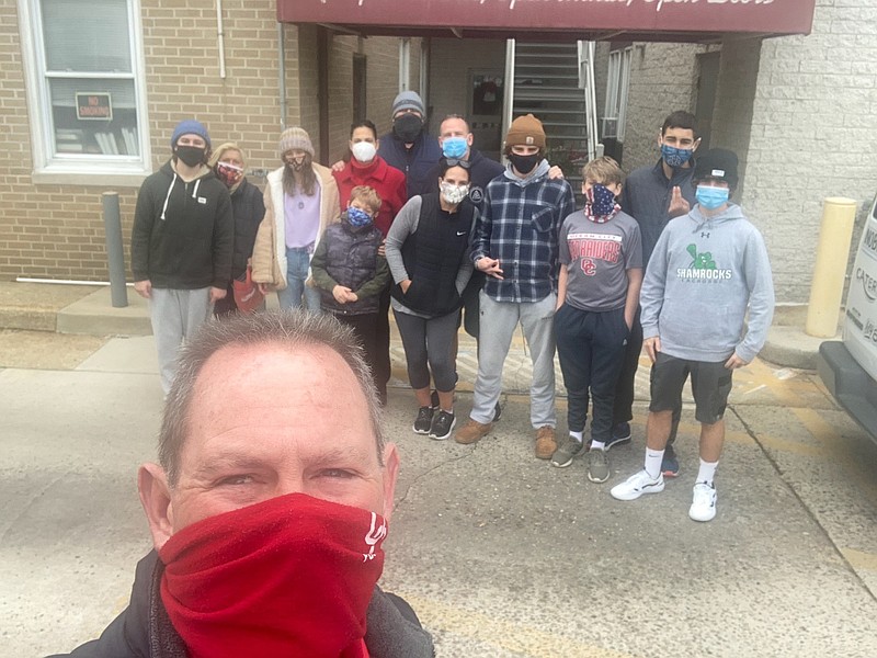 Drew Fasy, red facemask, takes a selfie with other volunteers in background. (Photo courtesy Jen Bowman)