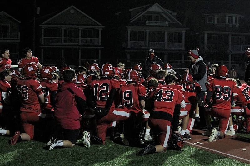 Head Coach Kevin Smith, standing at right, addresses his players during the Nov. 20 game against DePaul Catholic.