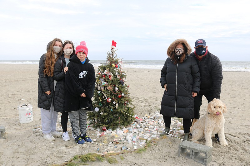 The Stampone family stands next to the Christmas tree for one more photo before it is taken down.