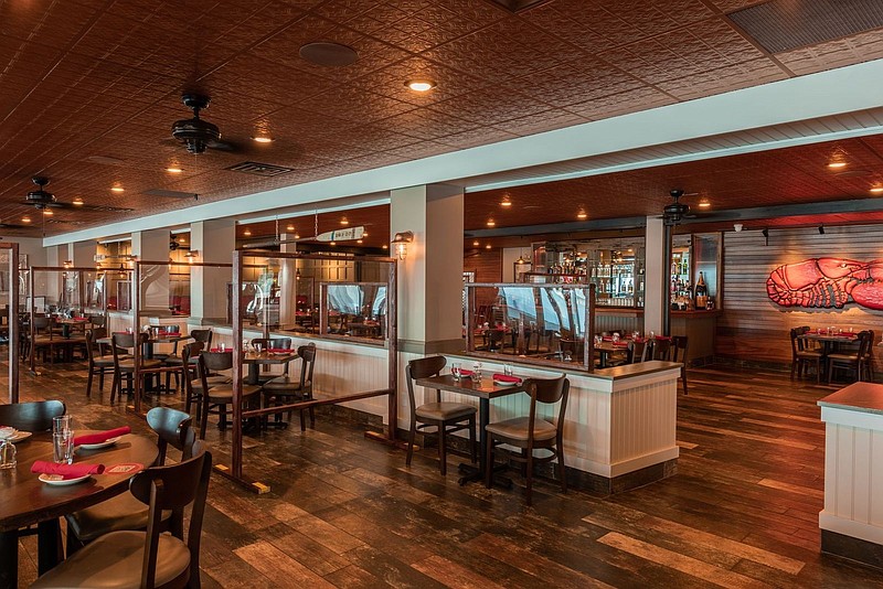 The main dining room includes Plexiglas partitions to separate the tables and create more space for social distancing during the pandemic. (Courtesy of Deauville Inn)