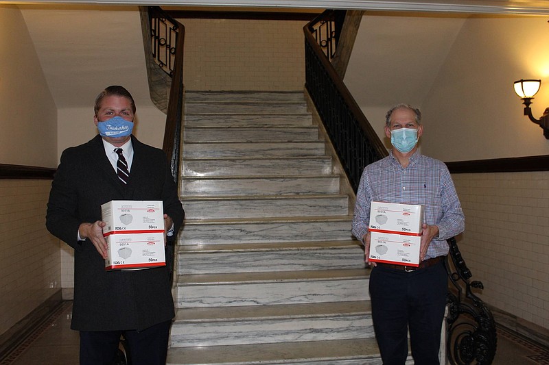 Ed Simonson, left, principal of the Simonson Law Firm, and Michael Allegretto, aide to Mayor Jay Gillian, hold boxes of masks that will help protect Ocean City municipal workers. (Courtesy of Ocean City)