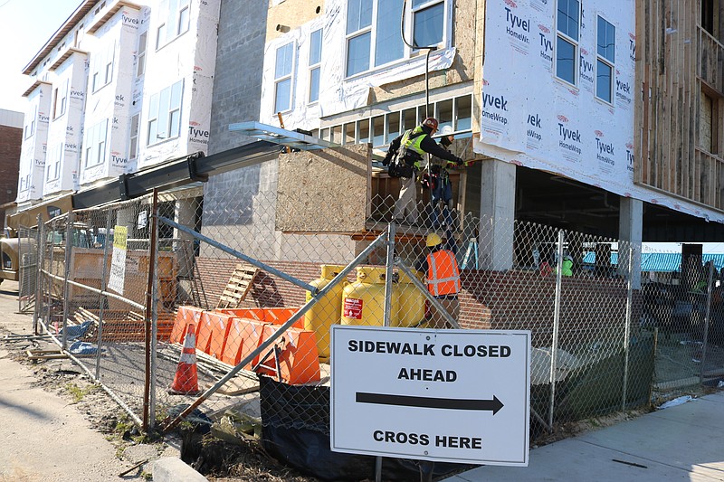 Construction crews perform work on the building's exterior.