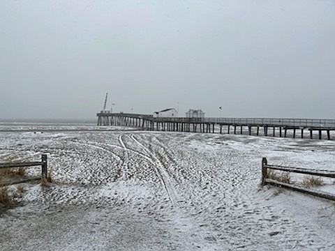 The snow creates a wintry beach scene near the Ocean City Fishing Club pier.