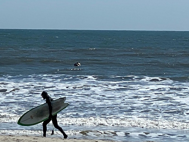 Surfers take advantage of waves on the first day of spring.