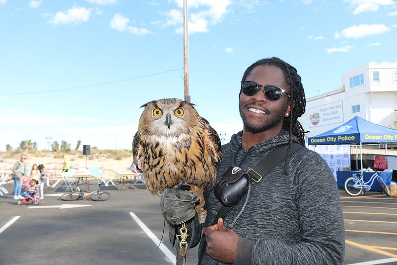 Donovan Meeks, a raptor expert employed by East Coast Falcons, shows off Eli the owl.