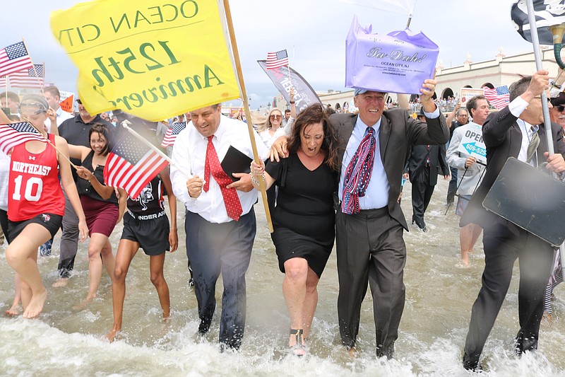 Participants sport suits and dresses for the cool dip.