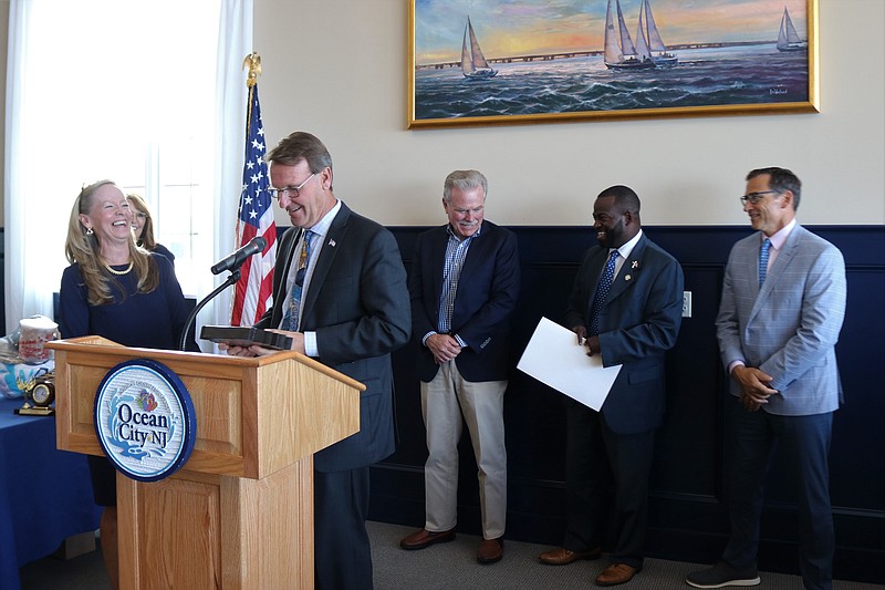 Award recipient Mary McGuckin, of Ocean City, receives a plaque from Mayor Jay Gillian during a ceremony. In the back from left, Michele Gillian, executive director of the Ocean City Regional Chamber of Commerce, dignitaries, Scott Halliday and Assemblyman Antwan McClellan and Chamber President David Allegretto.