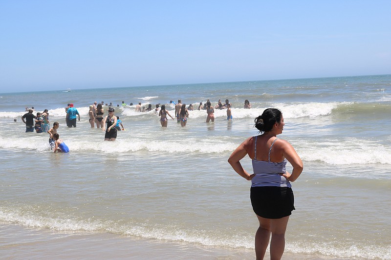 People splash in the ocean to cool off.