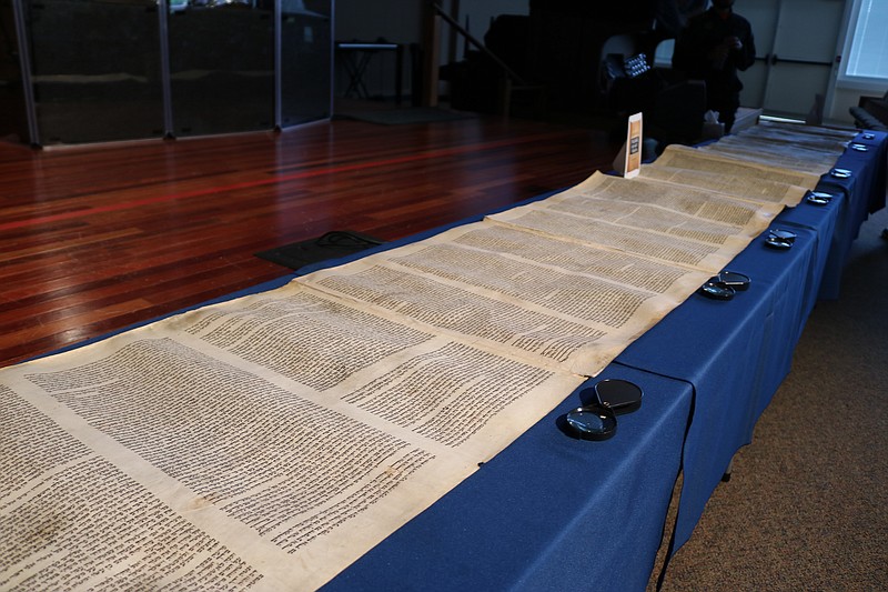 Artifacts, including this ancient scroll, are displayed for attendees to view.