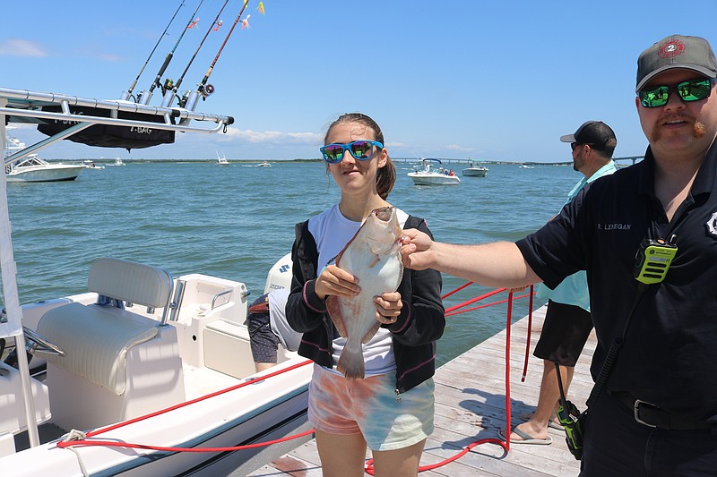 Isabella Felten, of West Cape May, proudly displays her catch after a fruitful day of fishing.