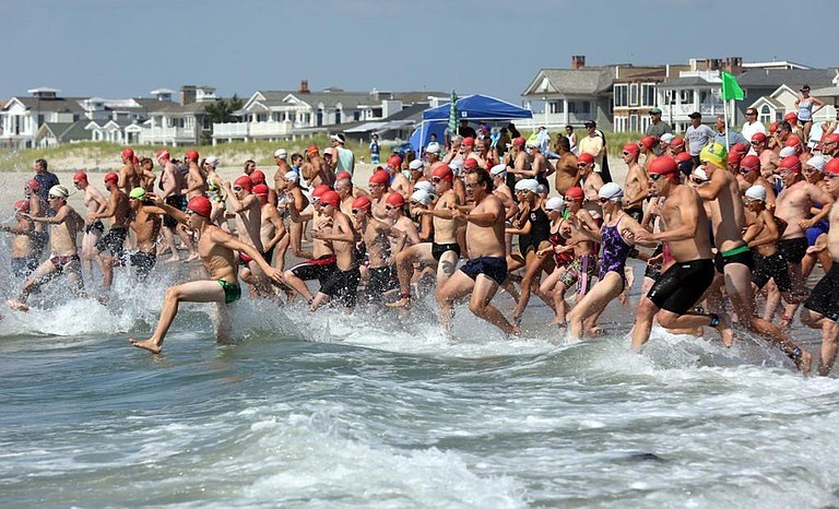 Competitors rush into the surf for the start of the T. John Carey Masters Ocean Swim. (Courtesy of ocnj.us)