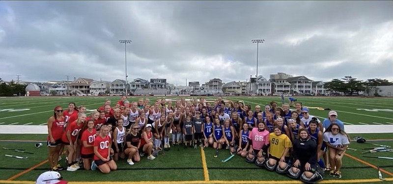 Both teams pose for a postgame picture.