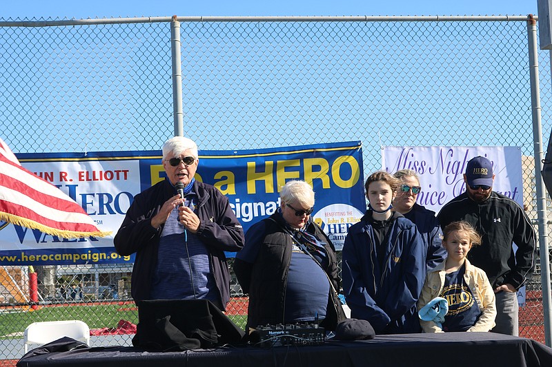 Bill Elliott speaks about the significance of the event, as Muriel Elliott bows her head.