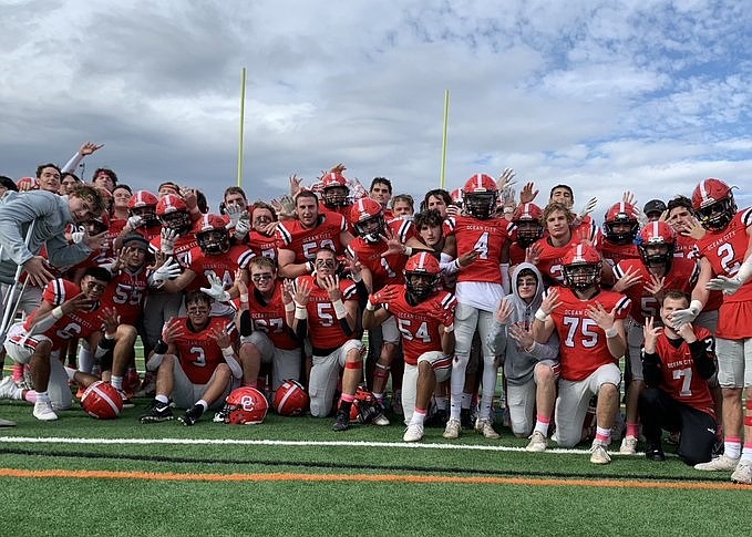 Ocean City's players each flash nine fingers to celebrate their perfect 9-0 record after defeating Williamstown. (Courtesy of Ocean City High School Football Twitter page)