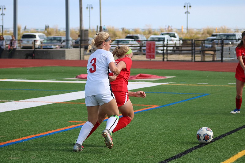 Zoey Lappin (in red) battles with a Delsea player for the ball.