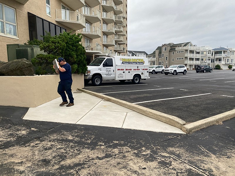 A worker puts something in front of his face to block the wind.