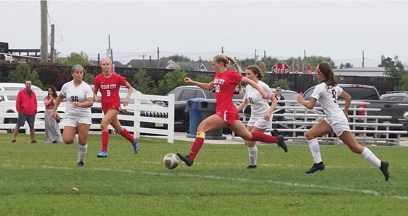 Displaying her ball control, Summer Reimet splits two defenders while charging toward the goal.